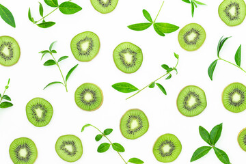  Summer bright background with slices of kiwi and green leaves on the gray surface