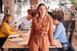 © Monkey Business - Portrait Of Businesswoman With Colleagues In Background Sitting Around Table In Open Plan Office