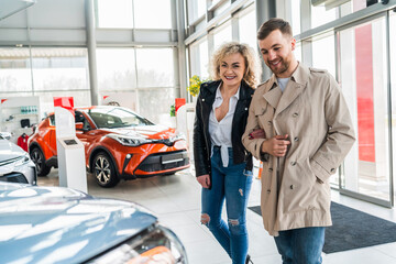 Wall Mural - Beautiful couple in car dealership chooses car