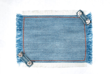 Frame denim with two straps jeans and rhinestones, lies on the light denim, with space for your text.