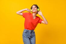 Photo Of Nice Brunette Optimistic Lady Listen Music Wear Headphones Red T-shirt Isolated On Vivid Yellow Color Background