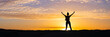 Silhouette of a confident young woman standing in the sunset. Power pose panoramic background