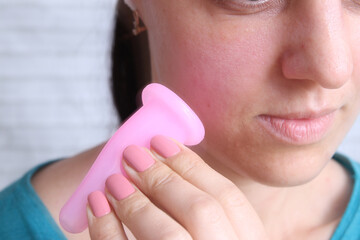 Close up silicone vacuum massager in female hands. Facial skin care, spa concept