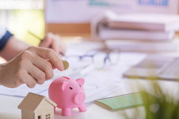 Entrepreneur or Businessman putting money coin to a piggy bank. Concept of saving for the future.