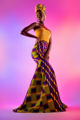 Wall Mural - Full length photo of magnificent young dark skin woman look empty space vogue tribal dress isolated on neon background