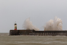 Waves Crash Against The Newhaven Harbour Wall During The Morning High Tide.