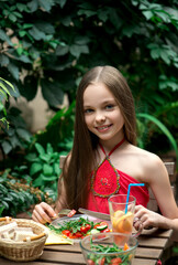 Cute little girl is eating  salad