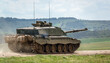 close up of a british army Challenger 2 ii FV4034 main battle tank kicking up dirt in action on a military exercise,  Wiltshire UK