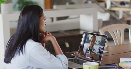 Poster - Mixed race female teacher sitting at table using laptop having online school lesson