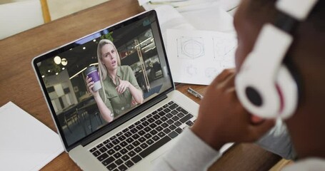 Sticker - African american male college student holding notes while having a video call on laptop at home