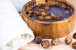 Brown dry soap nuts (Soapberries, Sapindus Mukorossi) in the water with the towel for organic laundry and gentle natural skin care on light background.