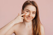 © Daria Lukoiko - Girl make face beauty masks. Anti-wrinkle cream for the freshness of the skin around the eyes. Woman take care of youthful skin. Model laughing and having fun in spa on pink background