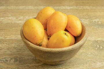 Wall Mural - Loquat fruits on wooden background.