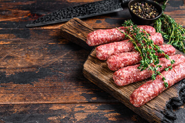 Wall Mural - Homamade raw meat lula kebabs sausages on a cutting board. Dark wooden background. Top view. Copy space