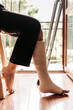 © stivog - Close-up of a woman with a broken ankle, sitting on a chair
