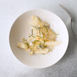 white bowl with pear salad, blue cheese and rosemary on the table