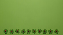 Four-leaf Clovers With Ladybug Decoration In A Row On The Bottom On Green Background - Copy Space