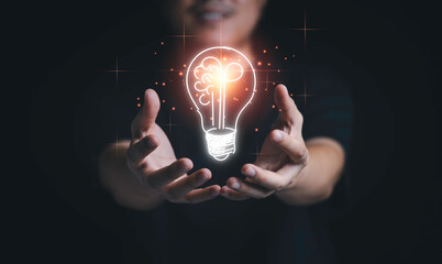 Fototapete - Man hand holding hanging glowing drawing light bulb with orange rays , creative thinking idea and innovation concept.