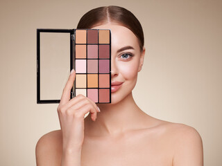 Wall Mural - beauty woman with eye shadow makeup palette. model with healthy perfect skin, close up portrait. cos