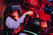 amazed teenager gaming on car racing simulator in vr headset