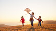 © JenkoAtaman - Happy family  mother and kids  launch  kite on nature at sunset