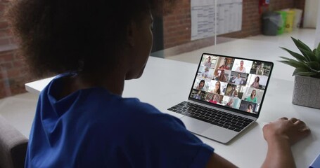 Wall Mural - Back view of african american woman having a video conference on laptop with colleagues at office