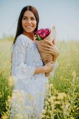 Wall Mural - Young woman in the rapeseed field