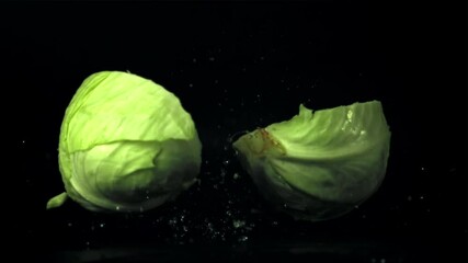 Wall Mural - The super slow motion of the cabbage fork splits into half. On a black background. Filmed on a high-speed camera at 1000 fps. High quality FullHD footage