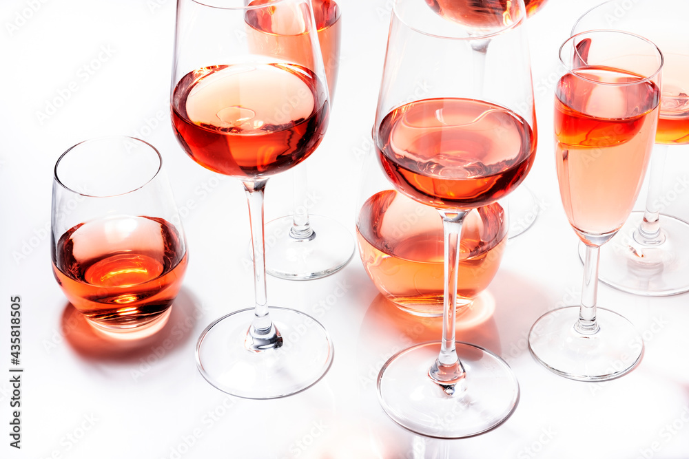 Rose wine glasses set on wine tasting. Different varieties, colors and shades of pink wines on white background. Top view - obrazy, fototapety, plakaty 