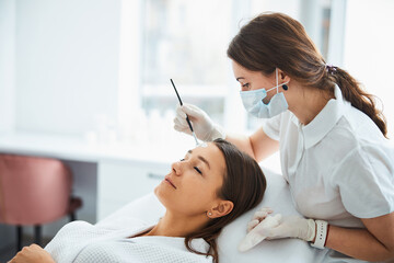 Wall Mural - Dermatologist applying a face mask to the patient skin