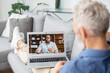 © Vadim Pastuh - Virtual meeting concept. African-American man on the laptop screen is holding video conference, talking and explaining something to senior grey haired man, two male business partners connect via video