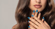 Beautiful girl showing blue  manicure nails . makeup and cosmetics. Brunette  woman with long  and   shiny curly hair