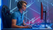 © Gorodenkoff - Professional eSports Gamer Plays First Person Shooter Video Game His Personal Computer, Trying to Set New Speedrun Record. Cyber Gaming Tournament / Championship. Side View Shot
