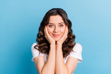 Canvas Print - Photo of funny dreamy young woman wear white t-shirt arms cheeks smiling isolated blue color background