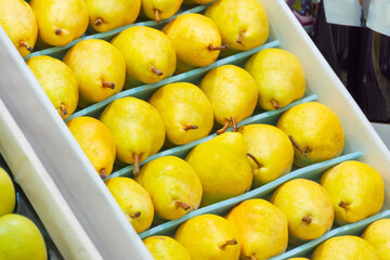 Wall Mural - Pears are laid out neatly in a row in a drawer on a supermarket counter.