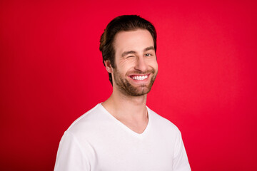 Sticker - Photo of cheerful positive happy charming man wink eye good mood smile isolated on red color background