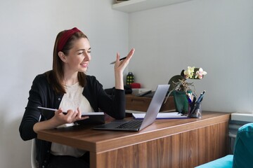 Businesswoman, female teacher working online at home with laptop using video call