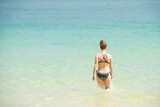 Fototapeta  - Summer day lifestyle woman relax and chill outdoors swimming at the sea. Vacations in Summer Tropical Beach Concept.