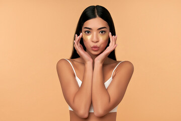 young asian woman in white lingerie and clean radiant skin with moisturizing patches under the eyes 