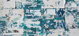 Fototapeta Desenie - Exposed Weathered Urban Wall with Torn Street Posters, Paper and Stickers. Vintage Billboard With Torn Poster, Paper, Ads Wide Grunge Background Or Texture.