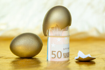 Wall Mural - golden eggs  with 50 euro  banknotes in eggshell, concept of enrichment and wealth	