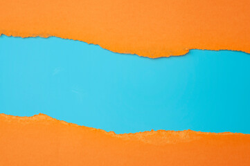 Horizontal border and colorful backgrounds concept with torn orange paper and copy space on blue background