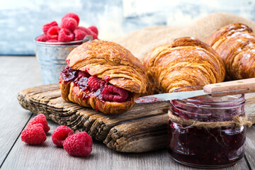 Wall Mural - Fresh croissants with raspberry jam close-up.