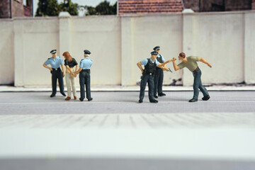  Miniature people of a girl or woman arrested by police and military security officer