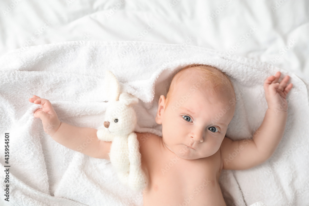Cute little baby lying on bed