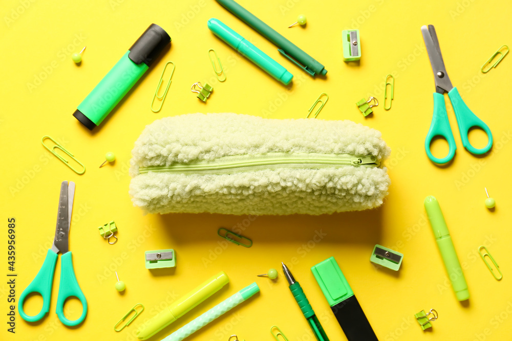 Pencil case and stationery on color background