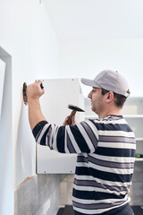 Wall Mural - Handyman worker making hole for airduct ventilation in the kitchen.