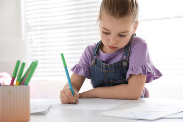 Canvas Print - Little girl writing in classroom at English lesson