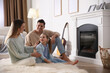 © New Africa - Happy family resting near fireplace at home