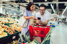 Happy Couple Buying Vegetables At Grocery Store Or Supermarket - Shopping, Food, Sale, Consumerism